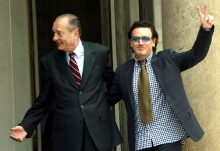 Irish singer Bono of the group U2 (R) flashes a V signs as he leaves the Elysee palace with French President Jacques Chirac, June 20, 2002. Photo by Eric Gaillard