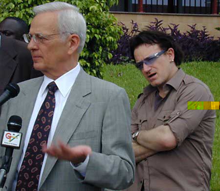 Treasury Secretary Paul O'Neill (L) speaks to reporters after visiting a data processing site in Ghana's capital with Irish rock singer Bono from U2, in Accra, May 21, 2002. Photo by David Clarke