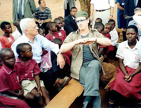 Irish rock singer Bono (R) and Treasury Secretary Paul O'Neill chat with pupils from an elementary school in Kampala, Uganda. May 27, 2002. Photo by Patrick Olum