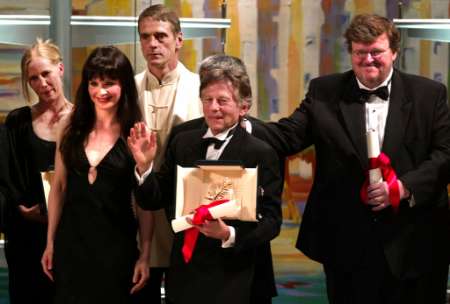 French Palme d'Or winner Roman Polanski (2nd R) thanks the audience as he stands beside 55th Cannes film festival anniversary award winner American director Michael Moore (R), French actress Juliette Binoche (2nd L), British actor Jeremy Irons (3rd R) and Best actress winner Finnish Kati Outinen (L) during the awards ceremony at the 55th Cannes Film Festival, May 26, 2002. Photo by Eric Gaillard