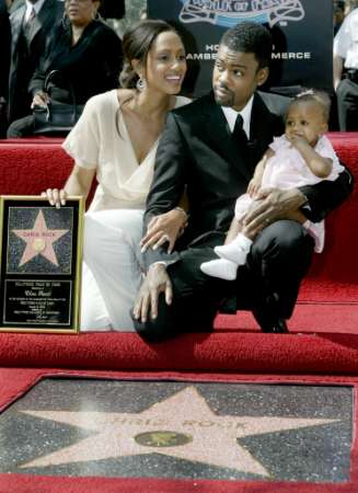 Actor Chris Rock holds daughter Lola after his star is unveiled on the Hollywood Walk of Fame as wife Malaak looks on during ceremonies in Hollywood March 12, 2003. Rock, an alumnus of 'Saturday Night Live' stars in the new comedy film 'Head of State' which opens March 28 in the United Stats. Photo by Fred Prouser