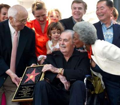 James Doohan (C) who played 'Scotty' in the 1960's TV series 'Star Trek,' with Hollywood's honorary mayor Johnny Grant (L) receives his Hollywood Star plaque August 31, 2004. With Doohan is his daughter Sara (on his shoulder) and his fellow cast menders from the TV series. From upper right, clockwise, are 'Chekov' Walter Koenig, 'Sulu' George Takei, and 'Uhura' Nichelle Nichols. Doohan's star is the 2,261st of the walk.   Photo by Gene Blevins