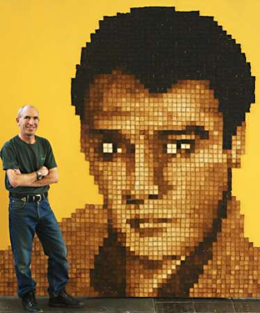 New Zealand artist Maurice Bennett stands with his giant portrait of the King Of Rock'n Roll, Elvis Presley, crafted out of more than 4,000 small slices of toast in this July 29, 2002 photo. Bennett, whose previous toast portraits include Leonardo da Vinci's enigmatic Mona Lisa and New Zealand rugby star Jonah Lomu, spent two months fashioning his unique ''toast'' to mark the 25th anniversary of Elvis Presley's death. Photo by Neil Price