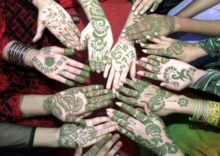 Pakistani women show their decorate hands with henna for the Eid al Fitr Festival in Multan December 5, 2002. Muslims around the world observe the holy 
month of Ramadan with religious zeal by abstaining from eating, drinking and sexual relations from dawn until dusk. The Muslim festival of Eid-al-Fitr 
is then celebrated at the end of Ramadan.  Photo by Asim Tanveer