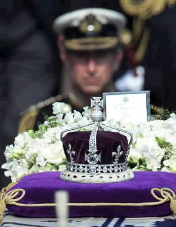 Prince Charles is seen behind the coronation crown as he follows the coffin of the Queen Mother during the procession to the lying-in-state at Westminster Hall in central London, April 5, 2002. The coveted Koh-i-Noor diamond forms the centerpiece of the crown. Photo by Russell Boyce