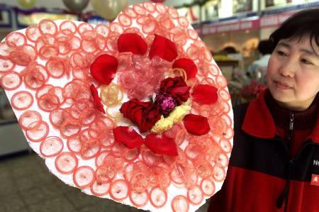 Une femme prsente un coeur compos de 100 prservatifs, ralis par un magasin de Pkin dsireux de participer  la lutte contre le sida. Les autorits chinoises ont lanc une campagne de prvention face  l'augmentation des cas de sida dans le pays. Photo by Wilson Chu