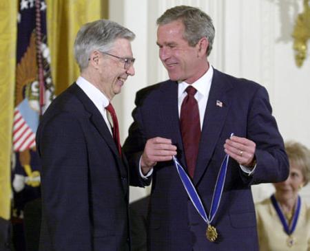 President Bush, right, prepares to place the Presidential Medal of Freedom on Fred Rogers, left, star of ''Mr. Rogers Neighborhood,'' a childrens show now in reruns after Rogers' retirement, which is the longest running program on public television, during a ceremony in the East Room of the White House, Tuesday, July 9, 2002, in Washington. Photo by Kenneth Lambert