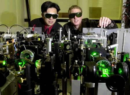 Physicist Dr Ping Koy Lam (L) and student Warwick Bowen look over their world breakthrough teleporting test equipment at the Australian National University in Canberra June 17, 2002. The successful teleporting test involving a laser beam of light being disembodied in one location and rebuilt in a different spot about one metre away in the blink of an eye, has been compared with the science fiction teleporting in the hit television series Star Trek. Photo by Graham Tidy